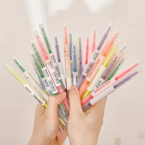 Hand holding vibrant double-headed dual-color highlighters in multiple colors