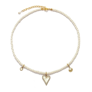 Detail of a pearl necklace featuring a shell heart pendant and golden clasp closure