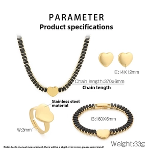 Détail d'une parure de bijoux en acier doré avec pendentifs en cœur de cristal noir
