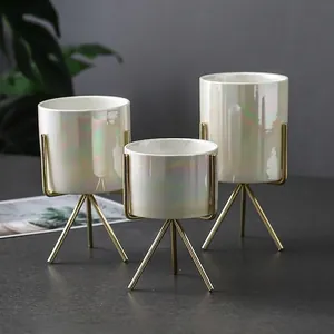 Three iridescent ceramic planters with gold metal stands in various sizes for home decor