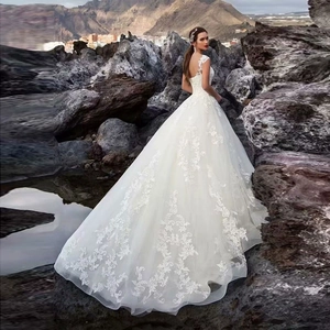 Elegant white lace wedding dress with open back and long train for bridal outdoor ceremony