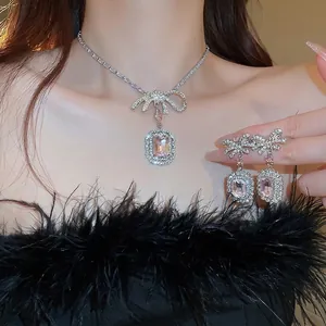 Parure de bijoux avec cristal rose et nœud en strass portée par un mannequin