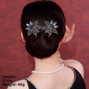 Détail de la pince à cheveux fleurs avec zircons bleus sur un chignon élégant