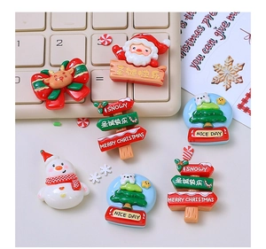 Flat lay of resin Christmas DIY charms including Santa Claus, snowman and bow decorations