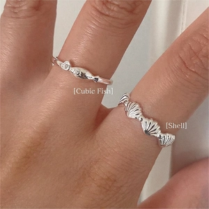 Sterling silver open rings featuring cubic zirconia fish and shell patterns on fingers
