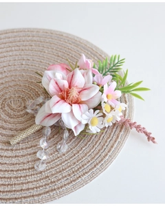 Gros plan d'une boutonnière de mariage avec fleurs artificielles roses et perles