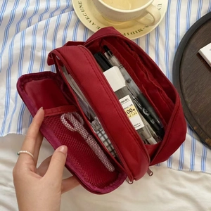 Macro view of burgundy nylon pencil case with mesh pockets and dual layered storage