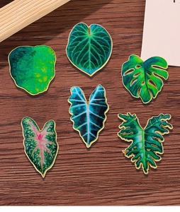 Detailed set of six tropical enamel plant leaf pins featuring monstera and caladium designs