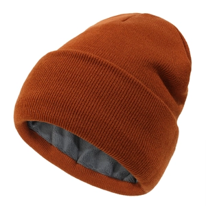 Detail view of winter knitted hat featuring thick grey fleece lining and caramel knit texture