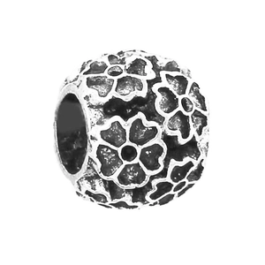 Macro detail of antique silver-plated 4mm floral beads with vintage relief patterns