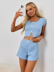Close-up of sky blue ribbed knit loungewear set featuring white bow and lettuce hem detail