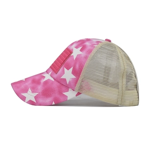 Side view of ponytail baseball cap featuring pink star pattern and beige mesh back