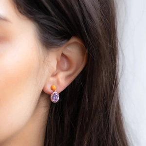 Detail of S925 silver asymmetric earrings featuring orange beads and purple enamel stones