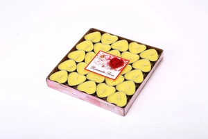 Macro detail of fifty yellow heart-shaped tea light candles in a romantic gift box