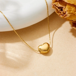 Minimalist gold heart pendant necklace in durable titanium steel shown in a lifestyle setting