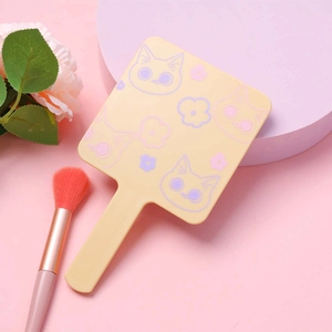 Cat pattern pale yellow handheld makeup mirror with handle on pink display stand