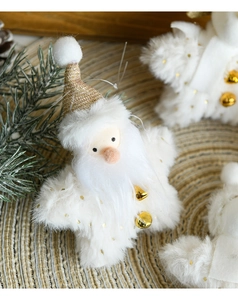 Detail of plush Santa ornament with white faux fur and golden bell on pine branch