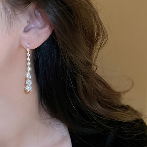 Gros plan sur les boucles d'oreilles pampilles argentées avec cristaux et pierres