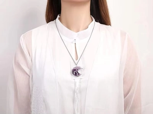 Gros plan du collier croissant de lune avec améthyste et motif arbre de vie en fil argent