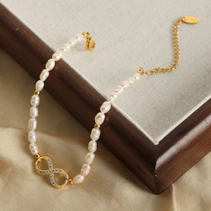 Elegant freshwater pearl bracelet with a sparkling gold infinity charm and cubic zirconia