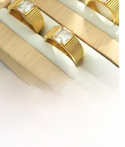 Close-up of gold plated ring with vertical textured band and rectangular zircon stone