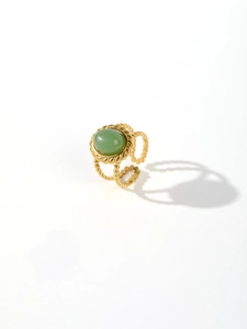 Detail of vintage gold plated ring featuring green stone inlay and beaded texture band