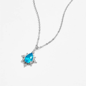 Close-up of S925 silver necklace with a snowflake pendant and teardrop blue zircon