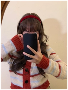 Detailed view of red velvet headband with silver rhinestones on brunette wavy hair