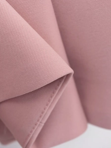 Gros plan sur un tissu sergé rose haut de gamme avec texture fine et beau drapé