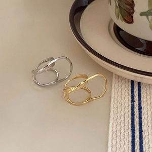 Minimalist double layer 925 silver wave rings in gold and silver set on a vintage tray