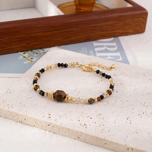 Detail showing vintage beaded bracelet with tiger eye stone and golden lobster clasp