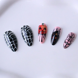 Halloween long almond press-on nails featuring pink pumpkins and spider web designs