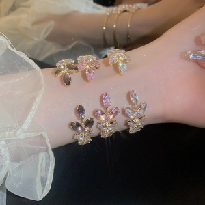 Close-up of sparkling leaf shaped bracelets featuring purple pink and white zircon stones