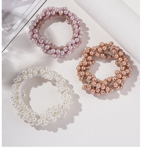 Three-piece set of faux pearl hair ties in pink, white, and brown colors for ponytail styling
