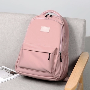 Pink minimalist aesthetic backpack with large capacity and multi-pocket design on sofa