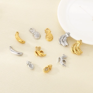 Detailed macro view of gold and silver hollow banana and pineapple metal pendants with rhinestones