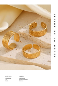 Detail view of gold adjustable rings set with vintage eye and floral relief textures