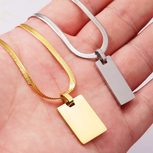 Gold and silver herringbone snake chains with rectangular bar pendants held in palm