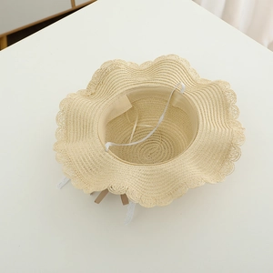 Vista interna del cappello di paglia beige con tesa a onde e cinturino elastico