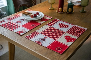Close-up of festive Christmas table runner set with red patchwork tree and heart patterns