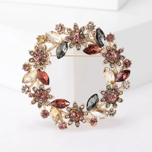 Elegant gold flower wreath brooch featuring multicolored rhinestones on a white background