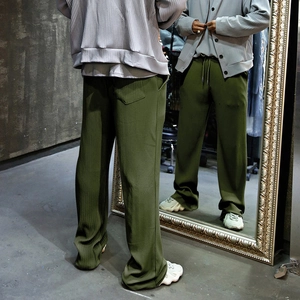 Detail view of olive green ribbed wide-leg trousers with vertical texture and drawstring