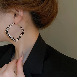 Side view of model wearing pink leopard print square hoop earrings with gold hooks