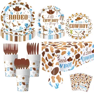 Flat lay of Western Cowboy party tableware set with cow print plates and napkins