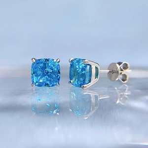 Macro shot of 1.5 carat blue cushion-cut stones on sterling silver stud earrings