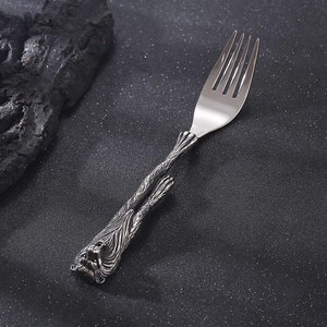 Makro-Detail einer Retro-Edelstahlgabel mit geschnitztem Löwenkopf-Griffdesign