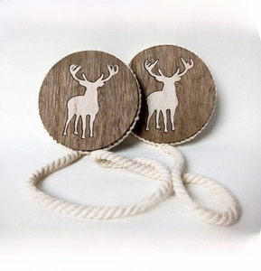 Detail of wooden magnetic curtain tiebacks with reindeer inlay and white woven cotton rope