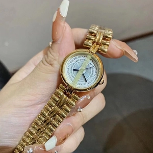 Close-up of a women's gold-tone quartz watch with metal bracelet and DINIMI engraved dial