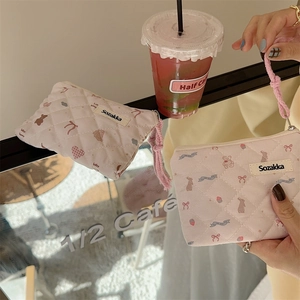 Detail of pink quilted floral pouch with cute animal patterns and braided rope handle