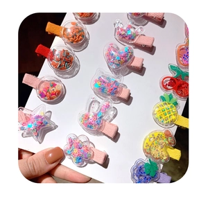 Detail of glitter hair clips with colorful sequins and fruit slices inside clear acrylic